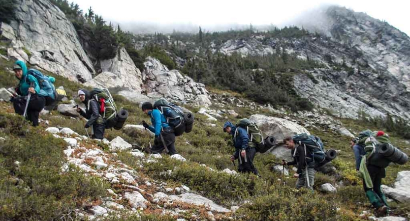 a group of outward bound students ascend rocky terrain 